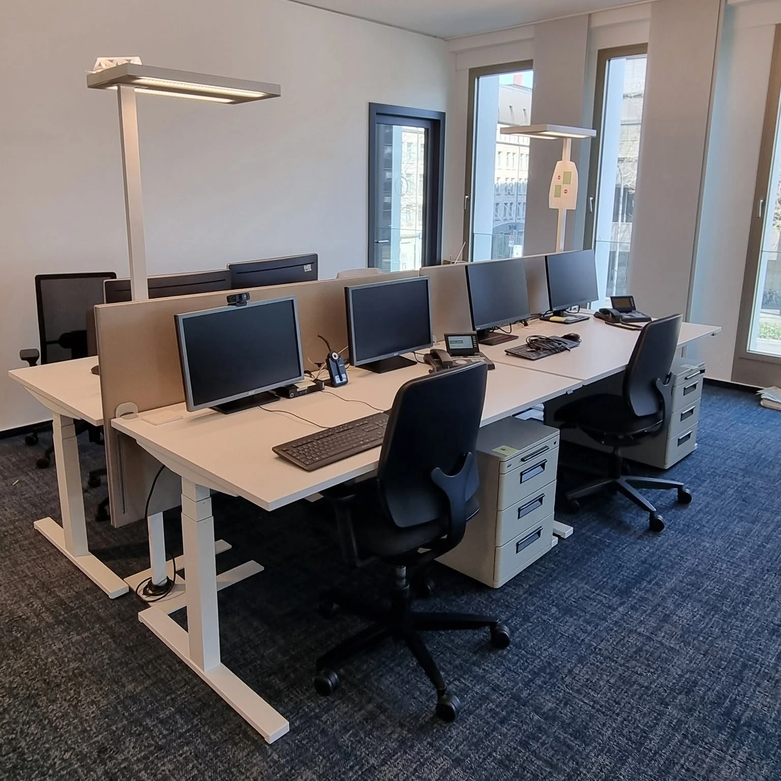 Büroarbeitsplätze mit Schreibtischen, Monitoren und Stühlen