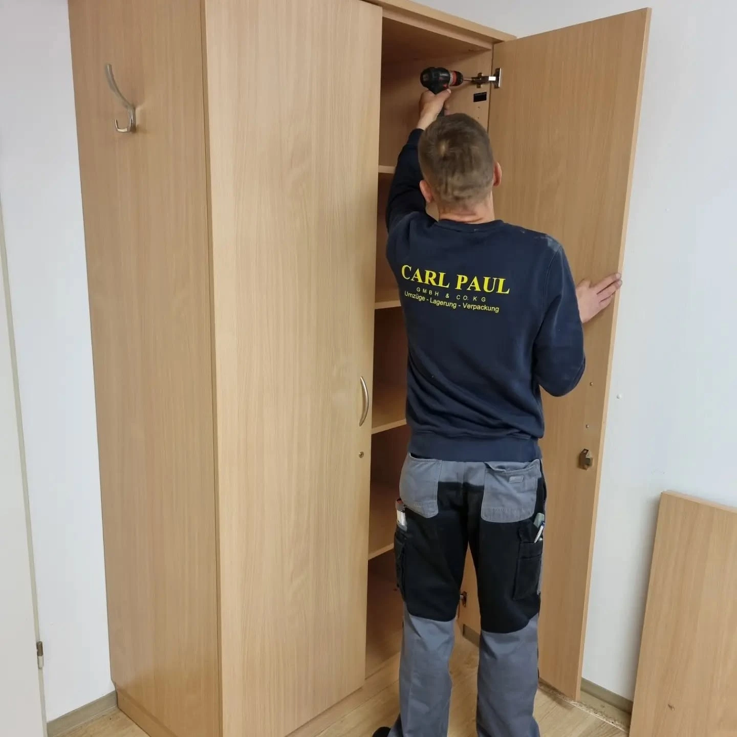 Mitarbeiter von Carl Paul bei der Montage eines Schranks