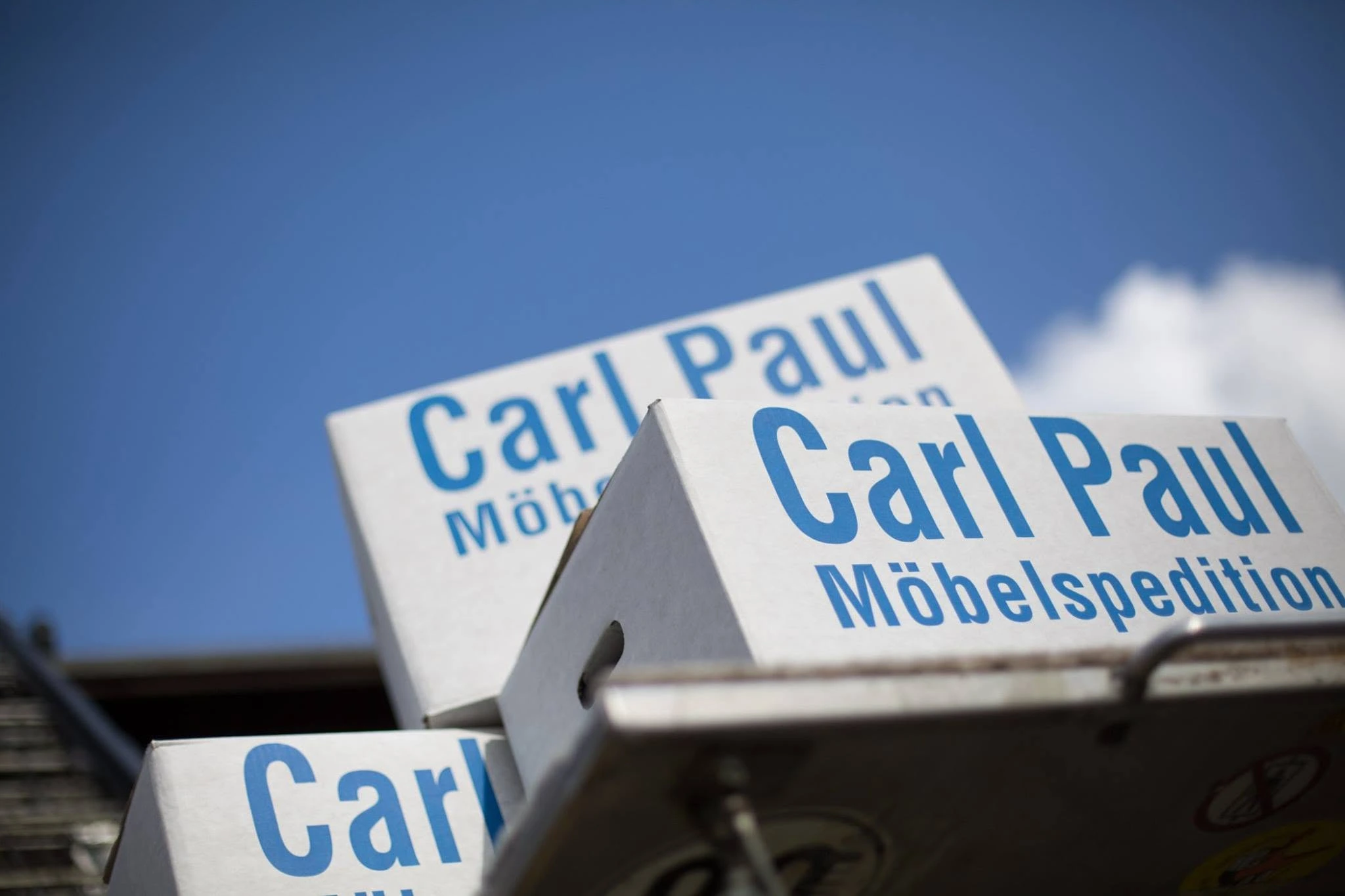 Umzugskarton von Carl Paul vor blauem Himmel